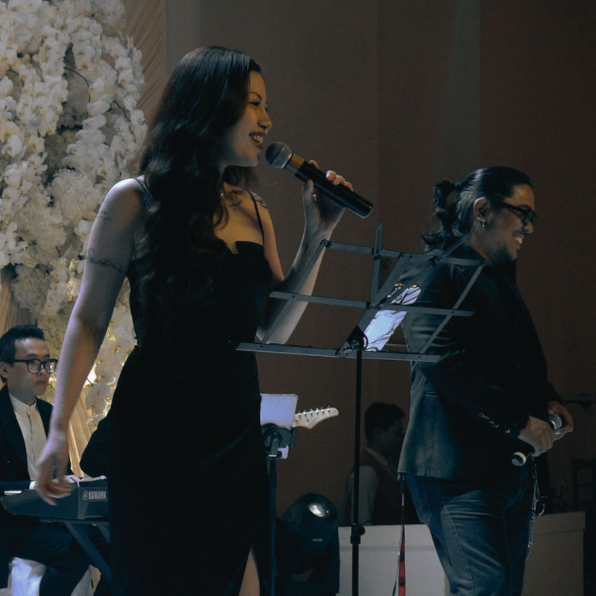 Hai vocalist biểu diễn cùng ban nhạc trong không gian tiệc cưới.