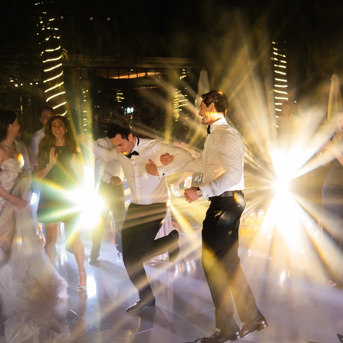 Chú rể và khách mời nhảy dưới ánh đèn trong phần after party.