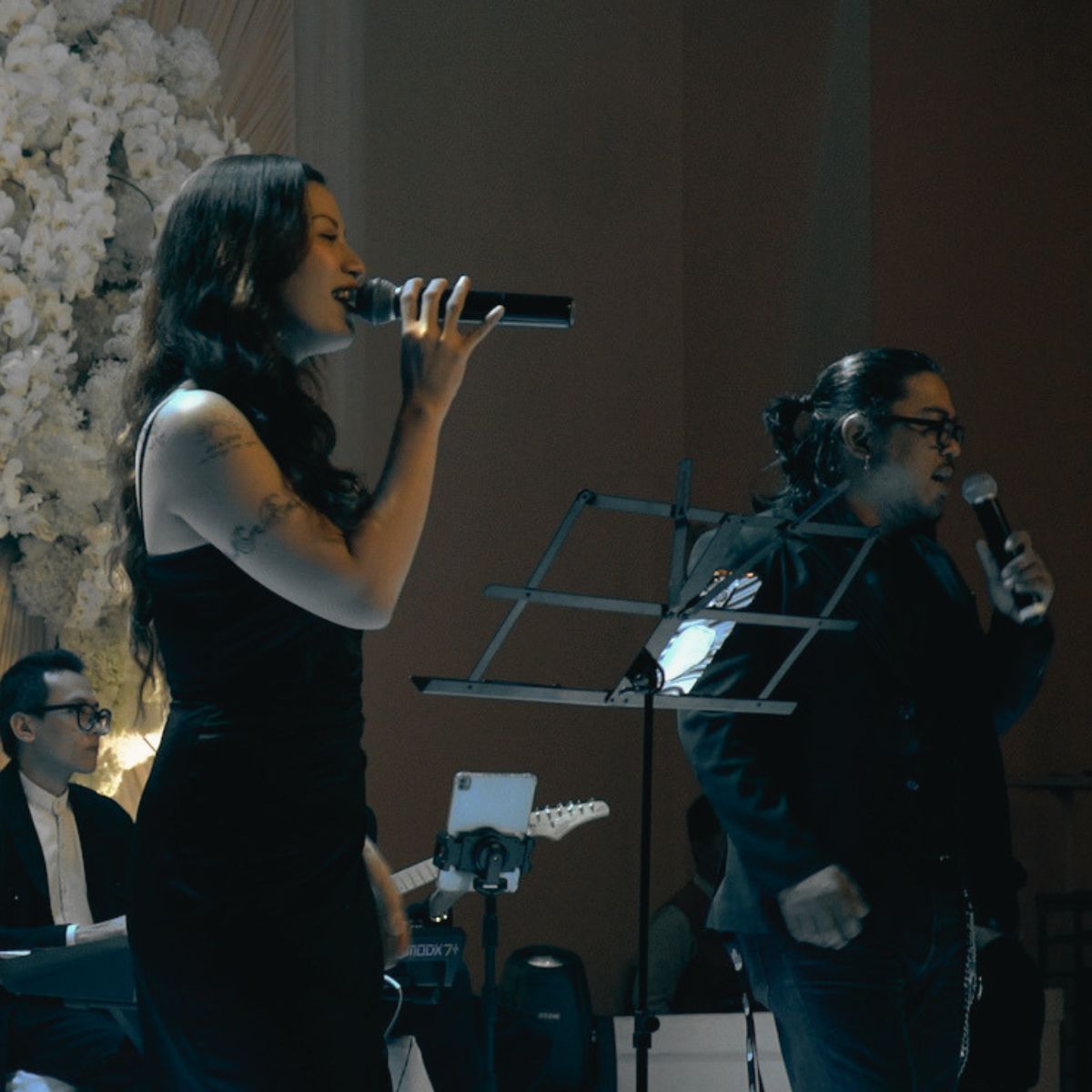 Hai vocalist biểu diễn cùng ban nhạc trong không gian tiệc cưới.