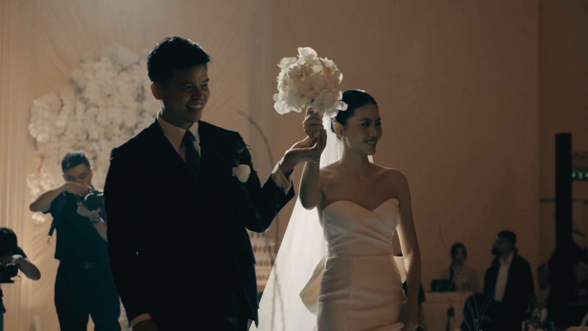 Cô dâu chú rể bước vào không gian nghi lễ cưới dưới ánh đèn