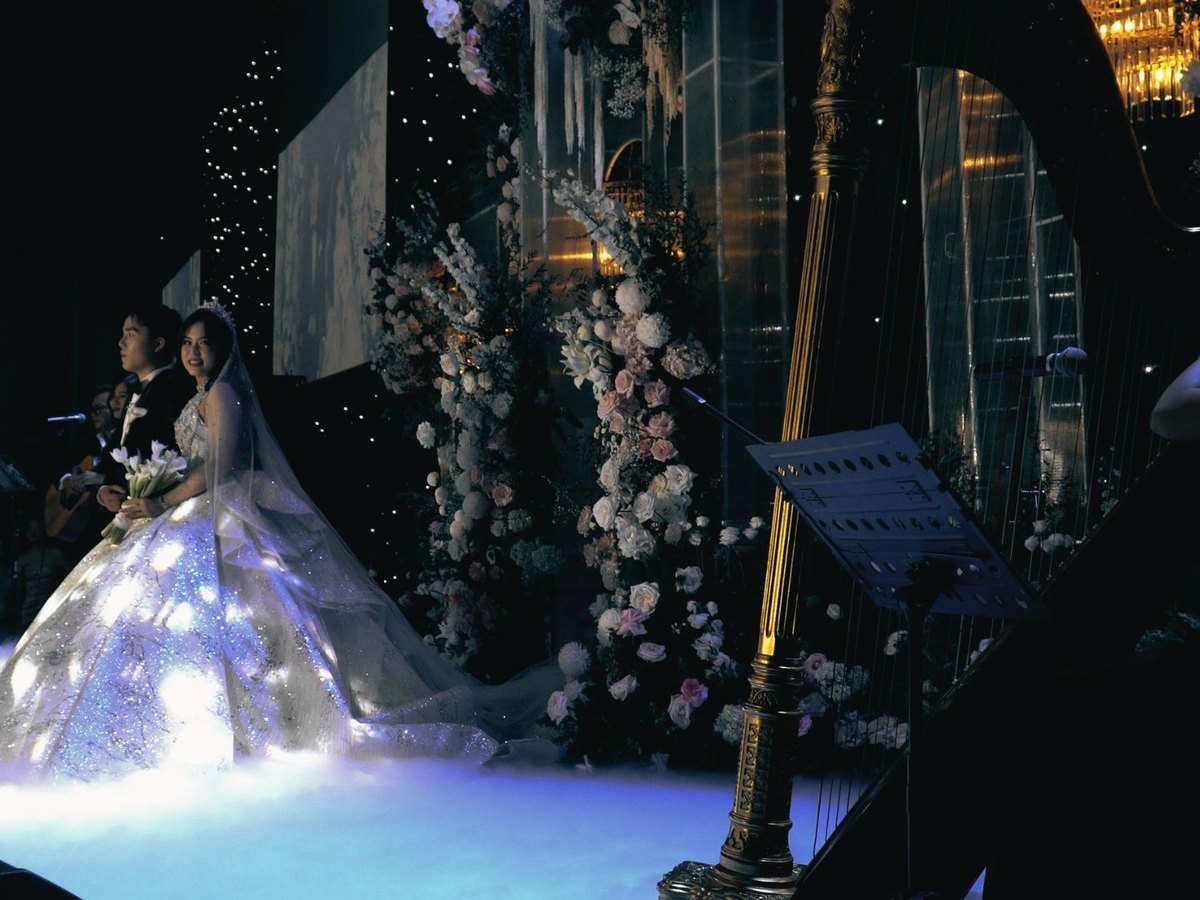 Cô dâu chú rể trong không gian lễ cưới với đàn harp và dàn hòa tấu bán cổ điển.